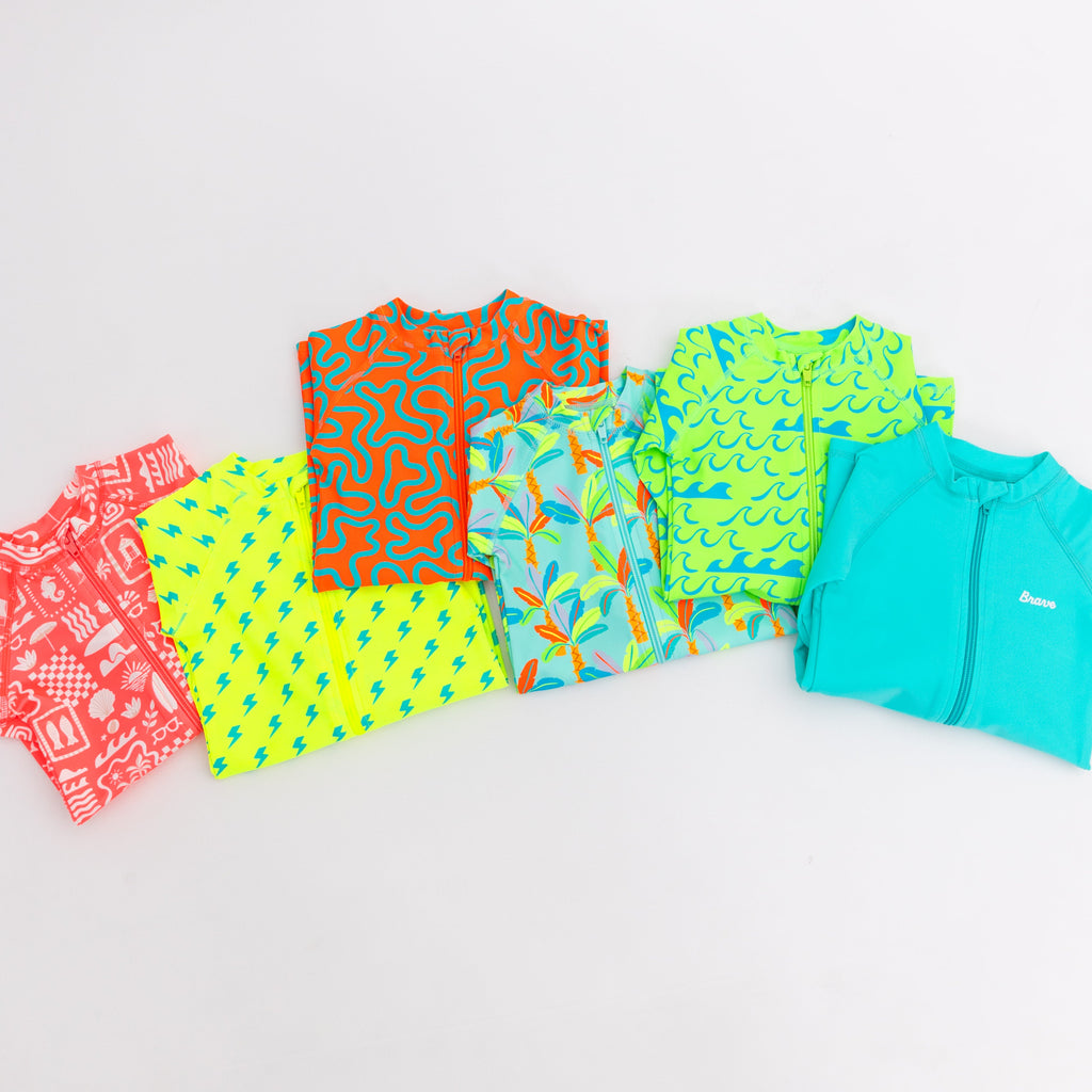 Colorful boy swimsuits stacked on a white background