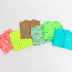 Colorful boy swimsuits stacked on a white background