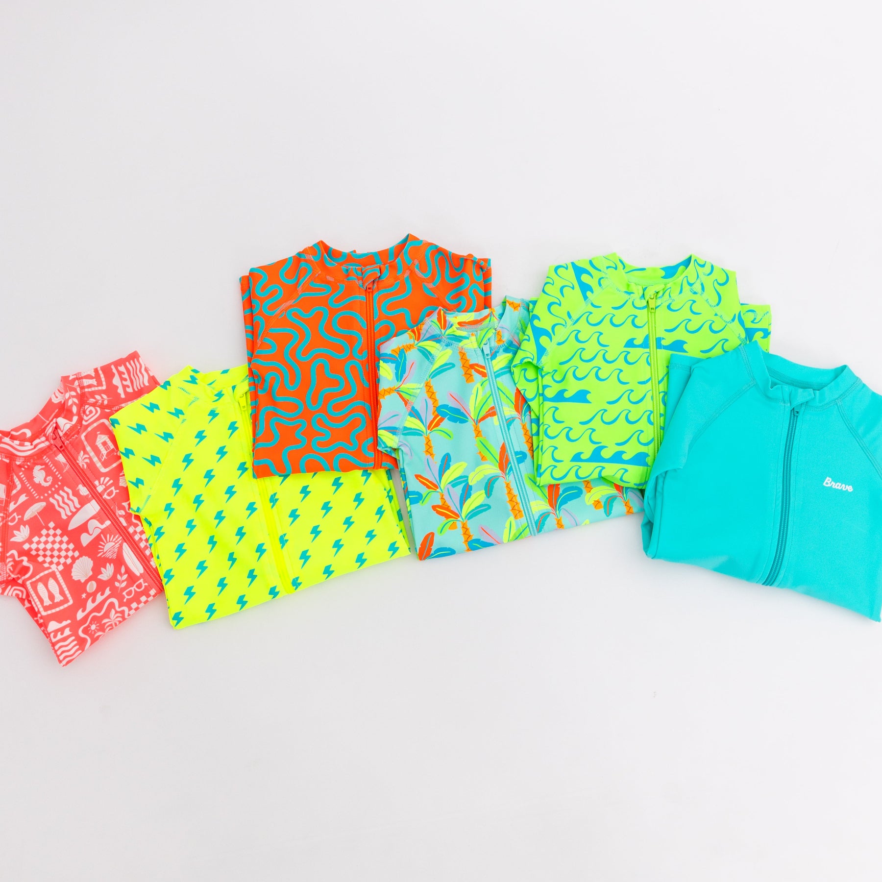 Colorful boy swimsuits stacked on a white background