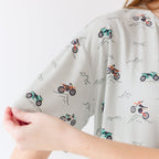 Close up shot of a woman wearing a light gray pajama with vehicle patterns on a white background