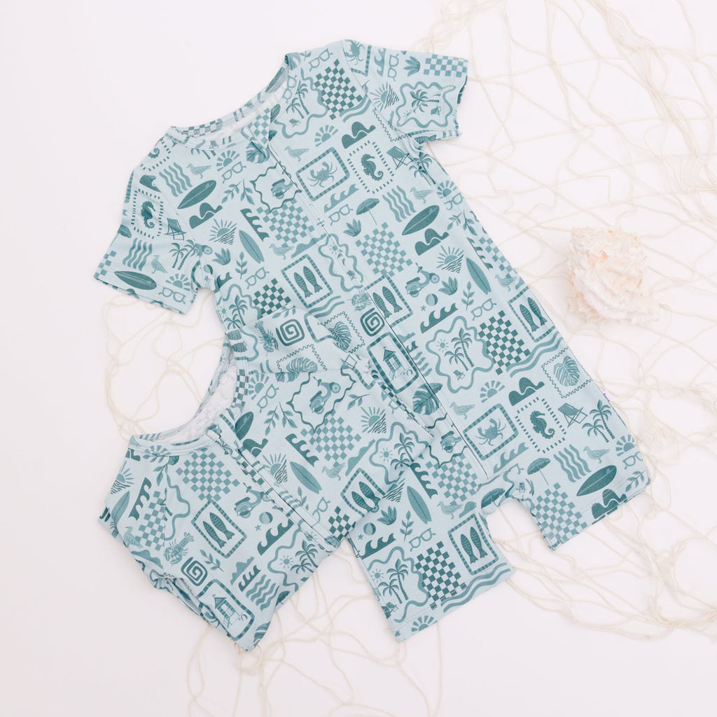 Children's pajamas with summer patterns on top of a fishing net placed on a white background
