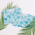 Set of blue palm tree patterned pajamas with green leaves on a white background