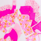 Pink and floral-patterned swimsuits on a white background