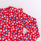 Close up shot of a red and white floral patterned swimsuit on a white background