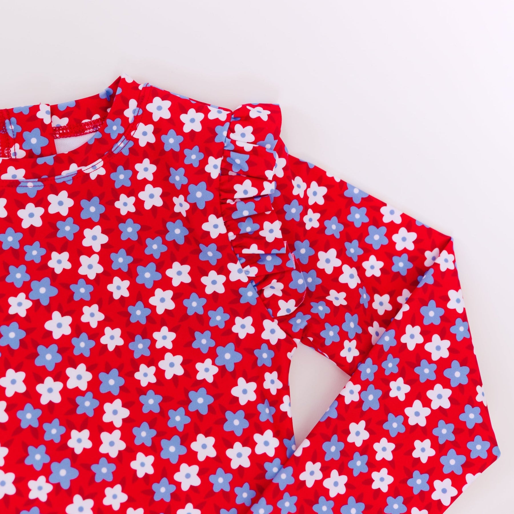 Close up shot of a red and white floral patterned swimsuit on a white background