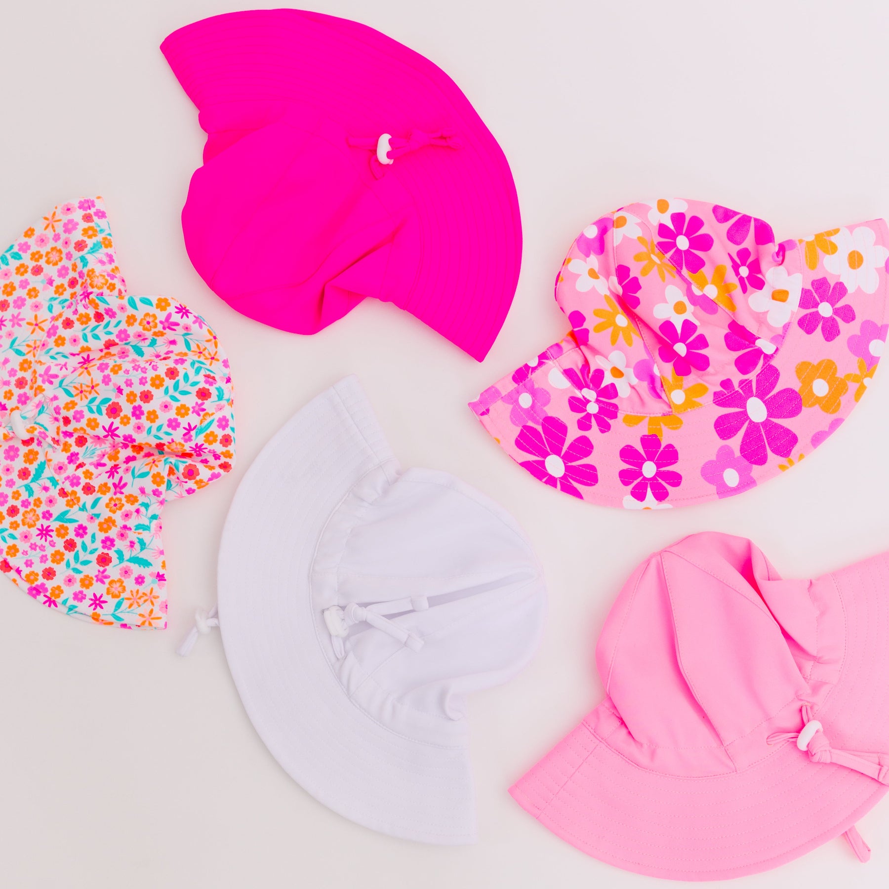 Set of colorful sun hats on a plain background
