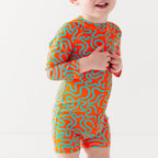 Child wearing a colorful swimsuit with a squiggly pattern on a white background