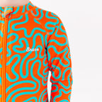 Close up of a child wearing a colorful swimsuit with a squiggly pattern on a white background