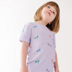 Child wearing a light purple t-shirt with animal prints on a white background