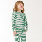 Child wearing green and white striped pajamas on a white background