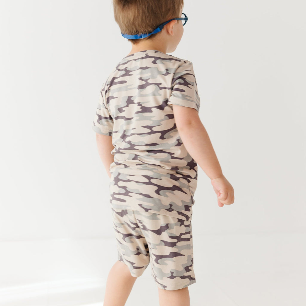 Child wearing a camouflage short pajamas on a white background