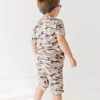 Child wearing a camouflage short pajamas on a white background