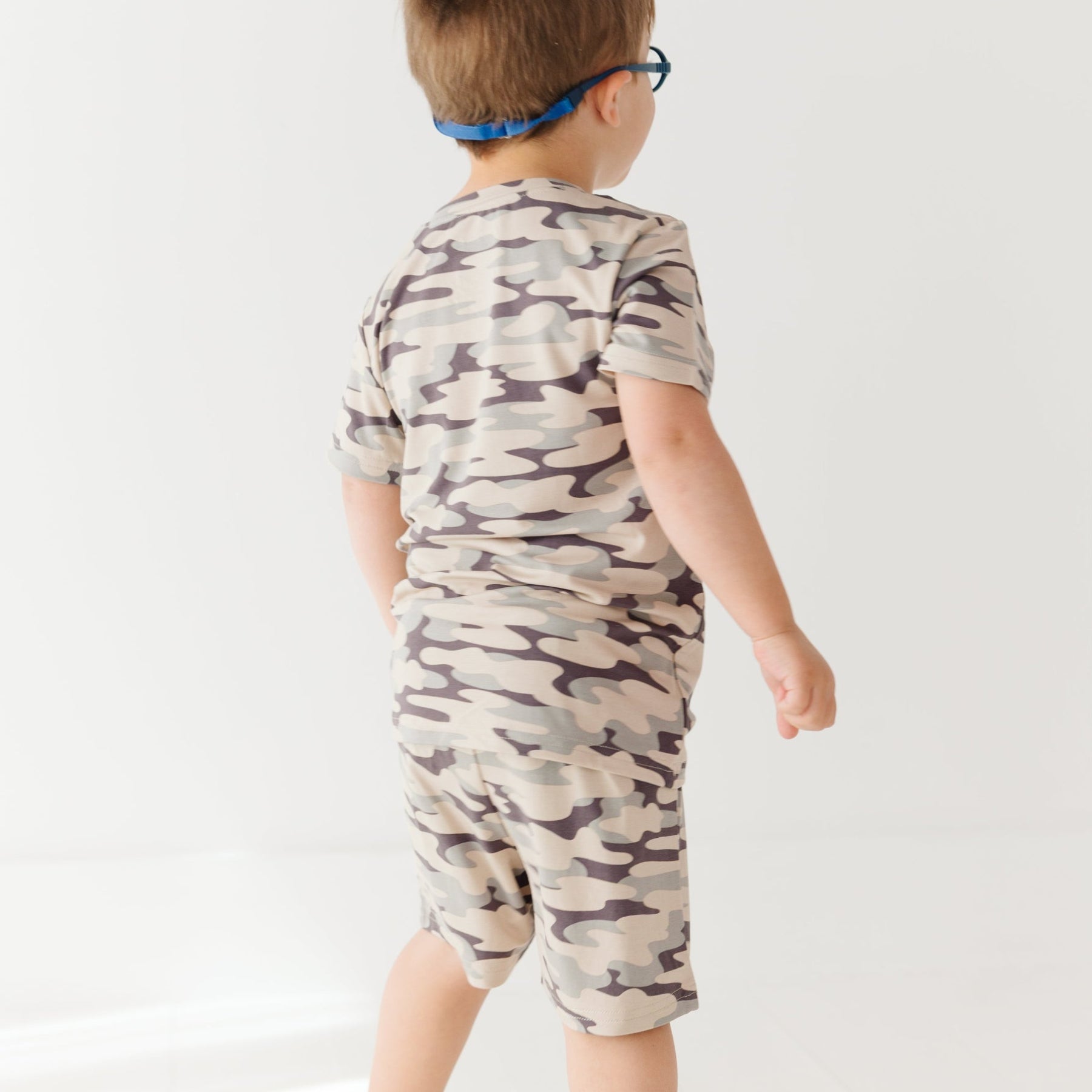 Child wearing a camouflage short pajamas on a white background