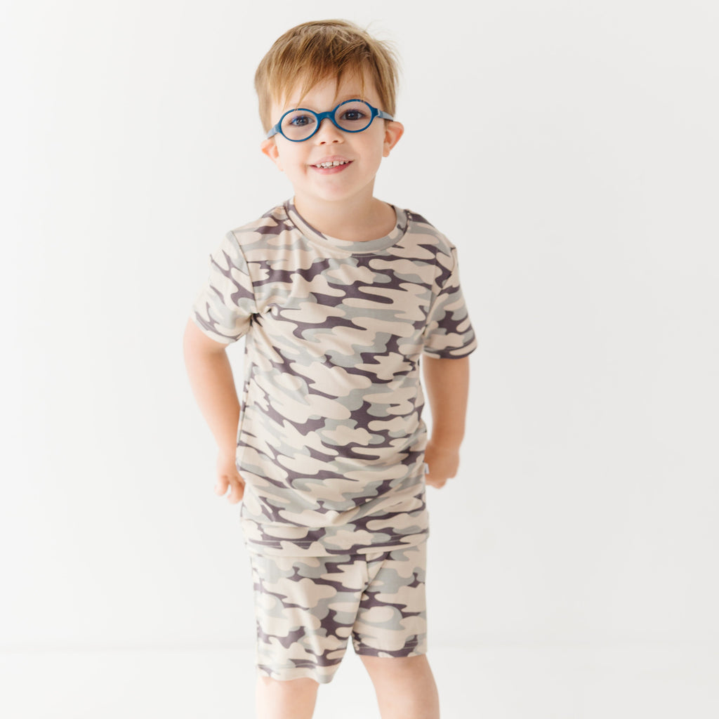 Child wearing a camouflage short pajamas on a white background