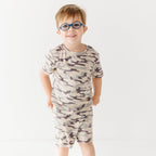 Child wearing a camouflage short pajamas on a white background
