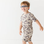 Child wearing a camouflage short pajamas on a white background