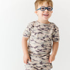 Child wearing a camouflage short pajamas on a white background