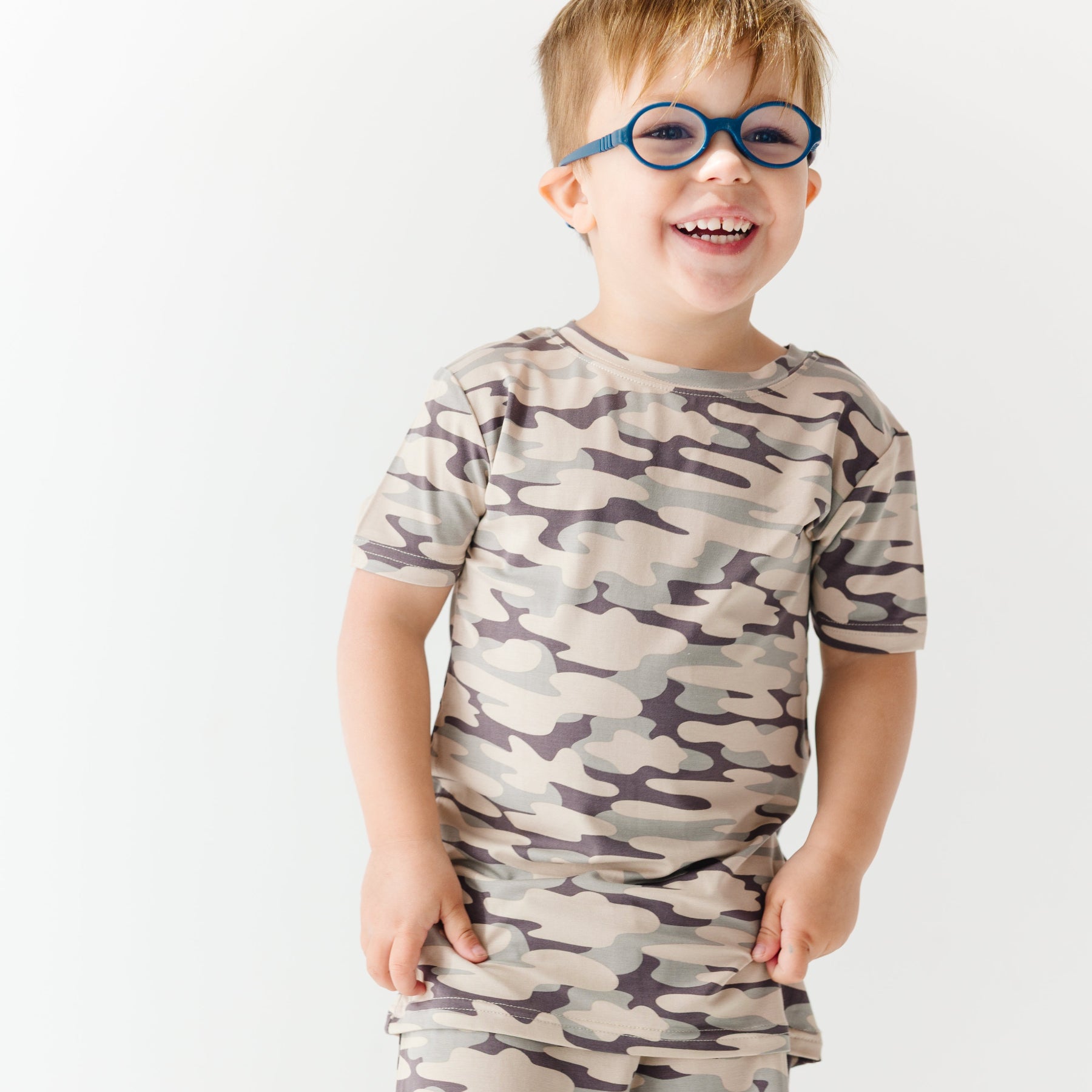 Child wearing a camouflage short pajamas on a white background