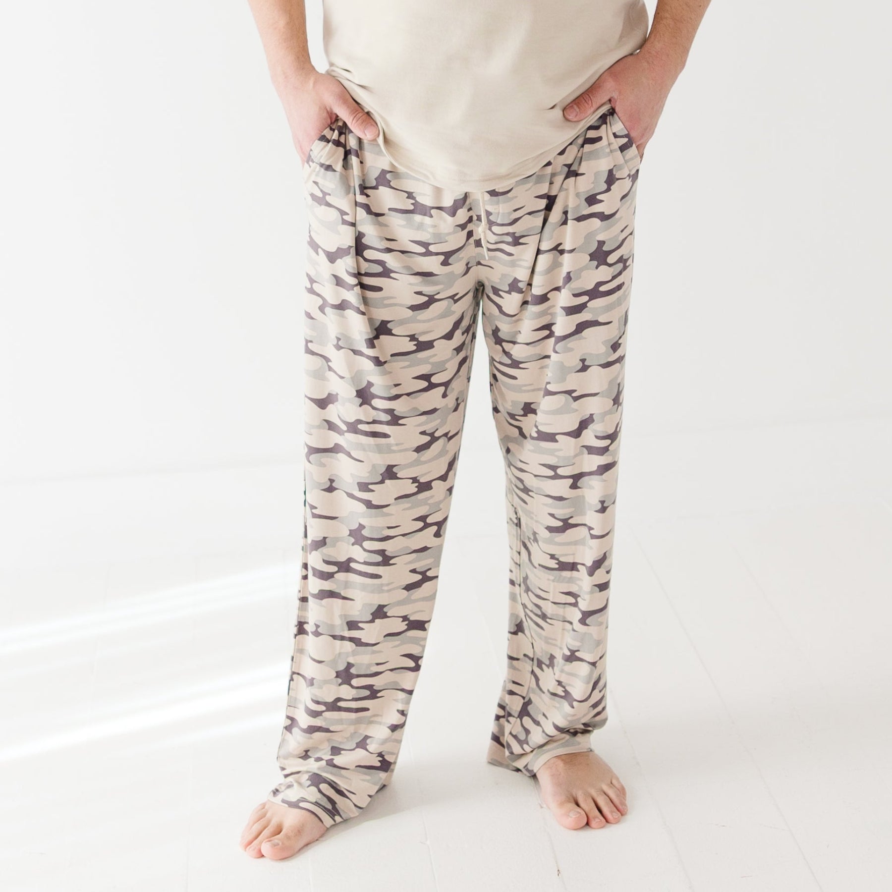 Person wearing camouflage pants on a white background