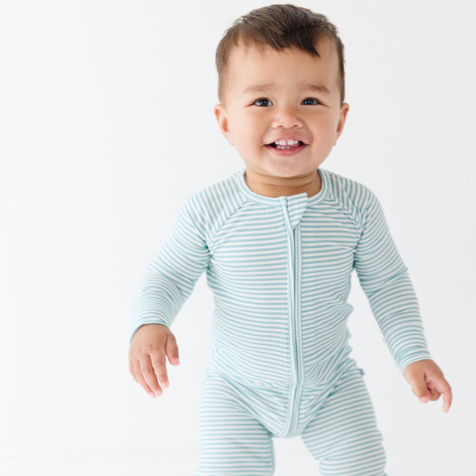 Baby wearing a light blue and white striped onesie on a plain background