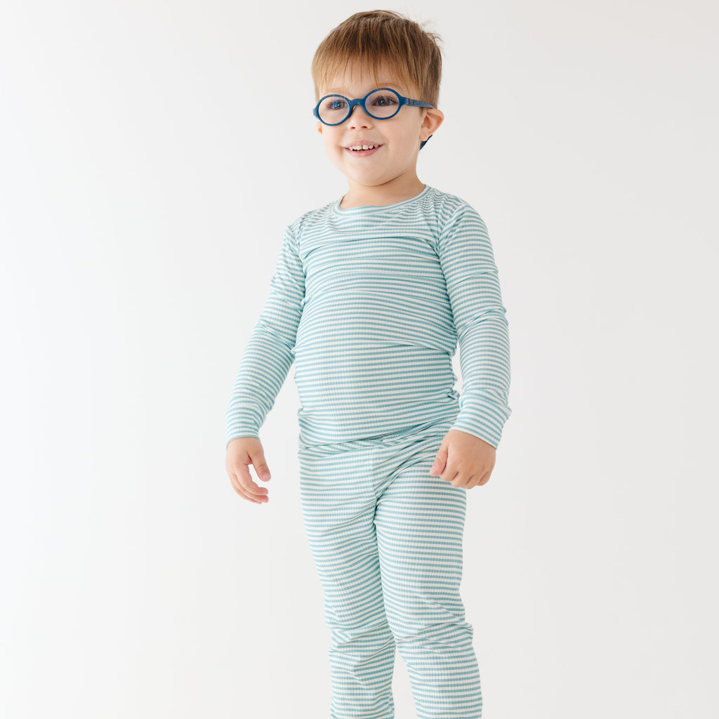 Child wearing a light blue striped pajama set on a white background