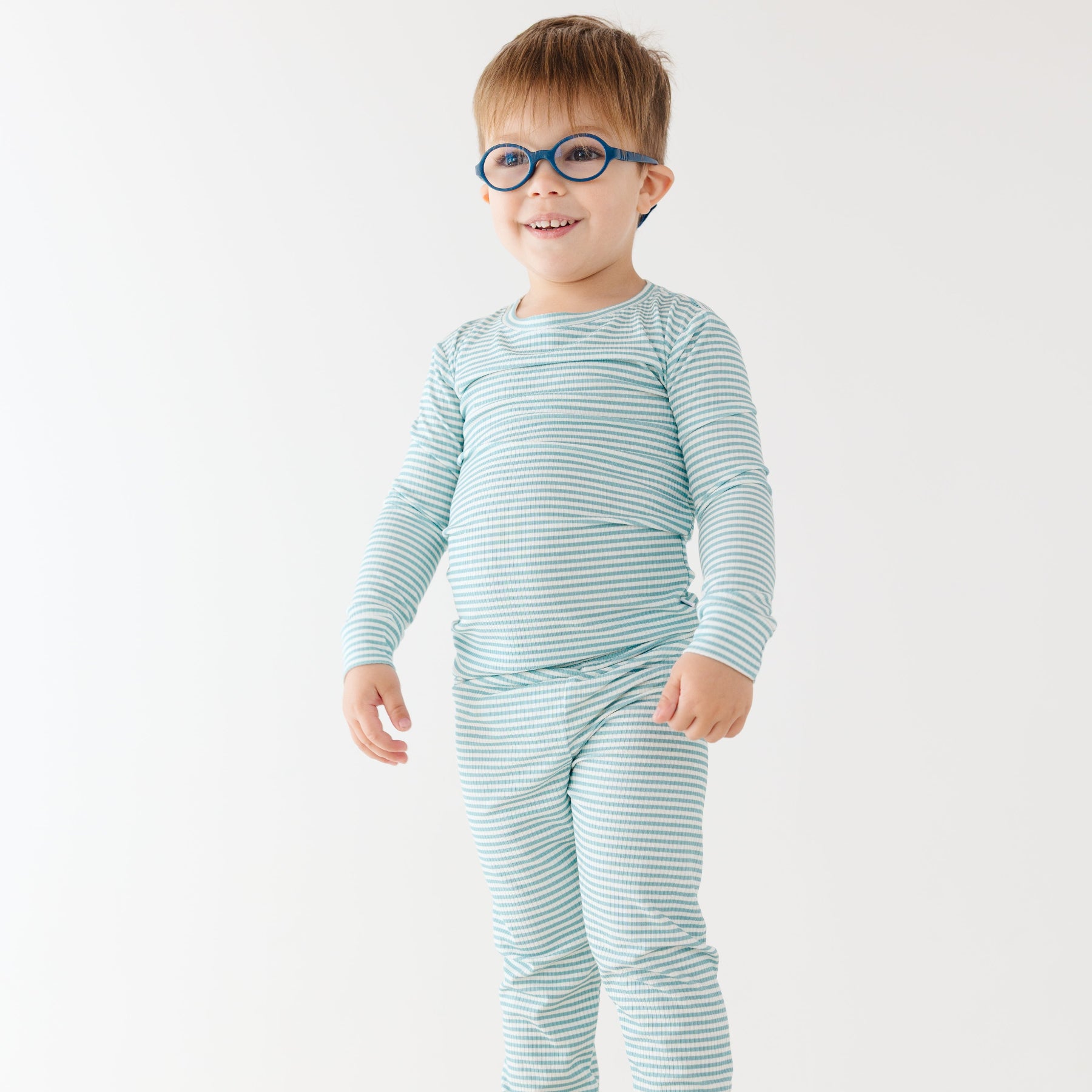 Child wearing a light blue striped pajama set on a white background