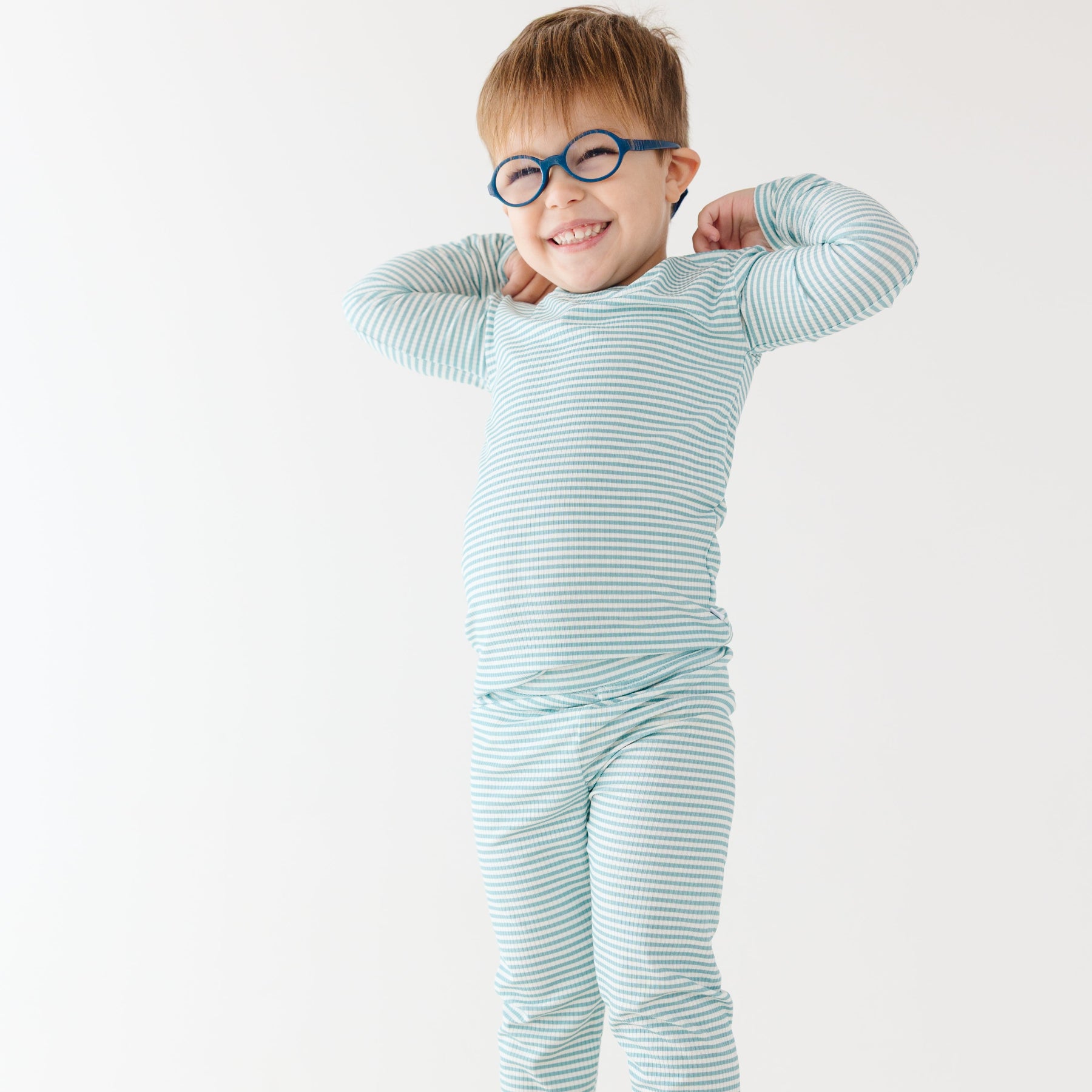 Child wearing a light blue striped pajama set on a white background