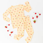 Yellow children's pajama set with fruit pattern on a white background