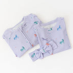 Baby outfit set with light purple ribbed fabric, including a onesie and headband with unicorn pattern on a white background.