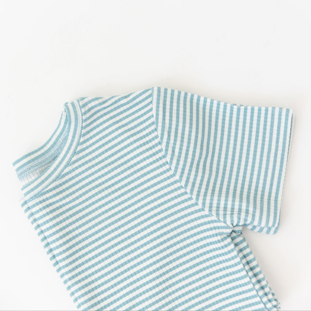 Folded blue and white striped shirt on a light background