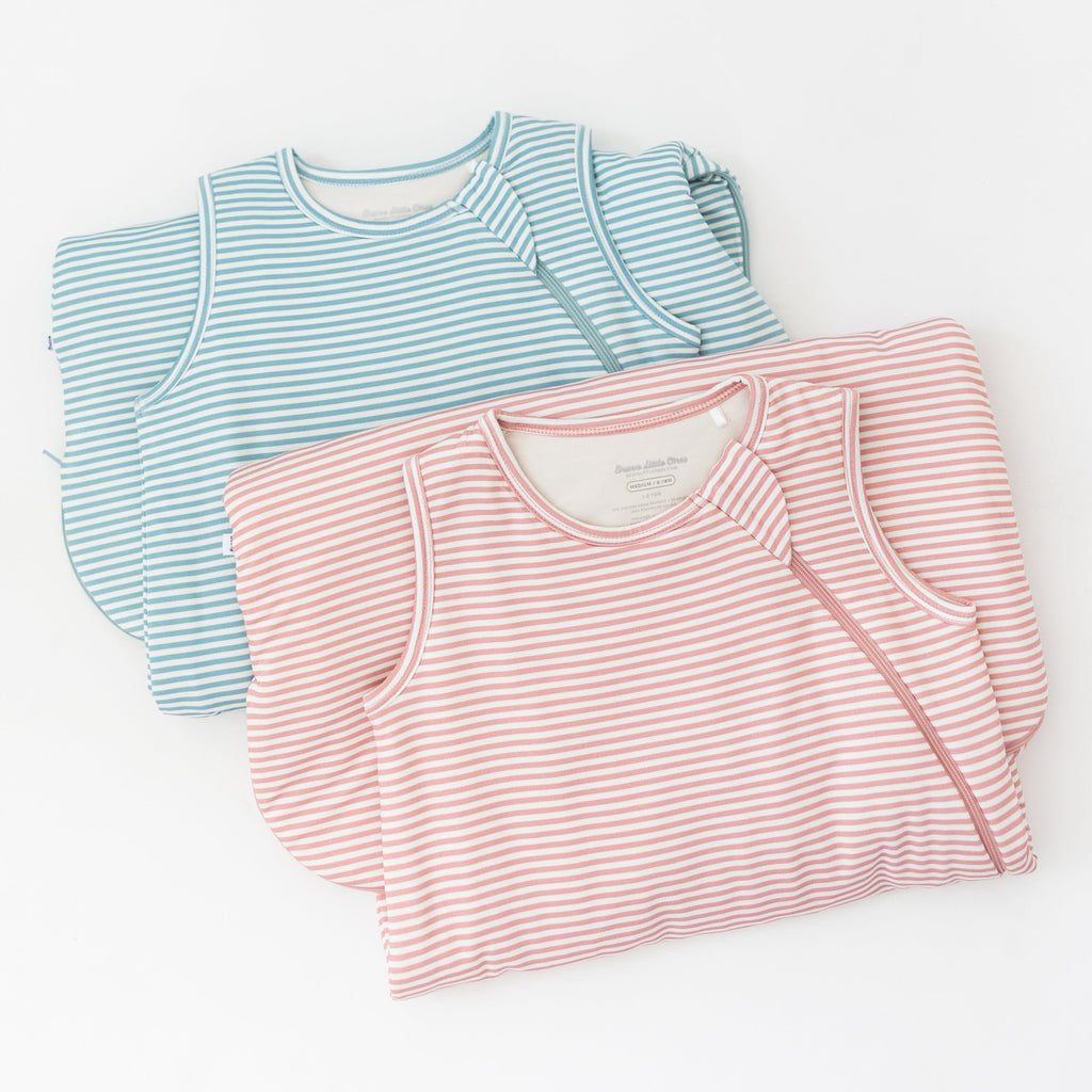 Two striped sleeping bags, one blue and white, one pink and white, on a white background
