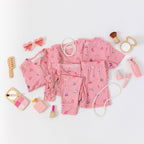 Collection of pink children's pajamas and accessories on a white background