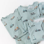 Light blue baby pajama sets with bicycle and scooter patterns on a white background