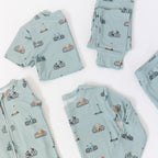 Light blue baby pajama sets with bicycle and scooter patterns on a white background