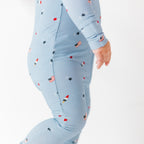 Close up shot of a baby onesie with small American flags and star patterns on a white background.