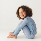 Child wearing a blue pajama set with stars and flag patterns on a white background