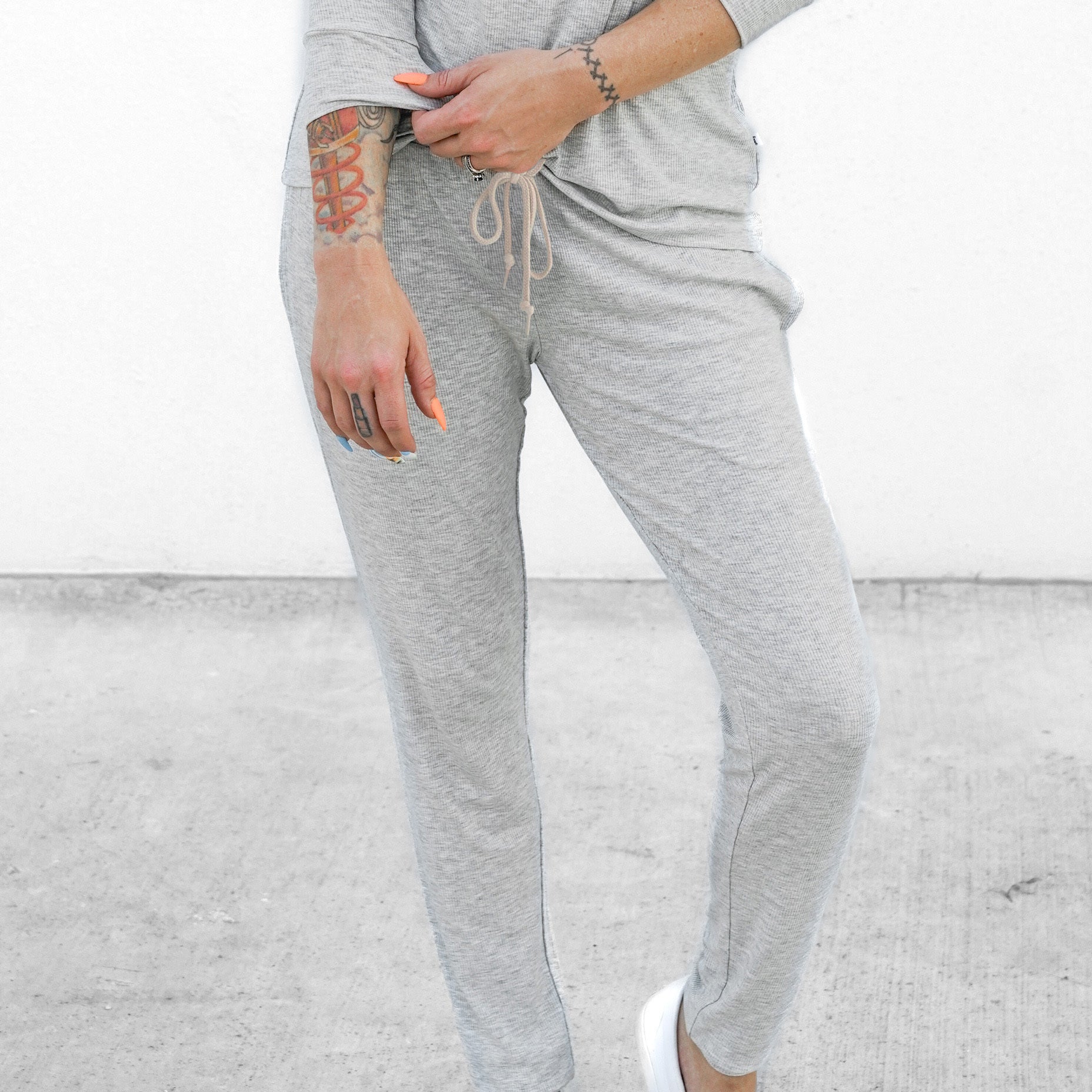 Person wearing gray sweatpants with a plain background