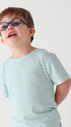 Child wearing a light blue striped shirt and shorts set on a white background