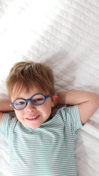 Video of a child lying on a bed wearing a blue and white striped pajama set