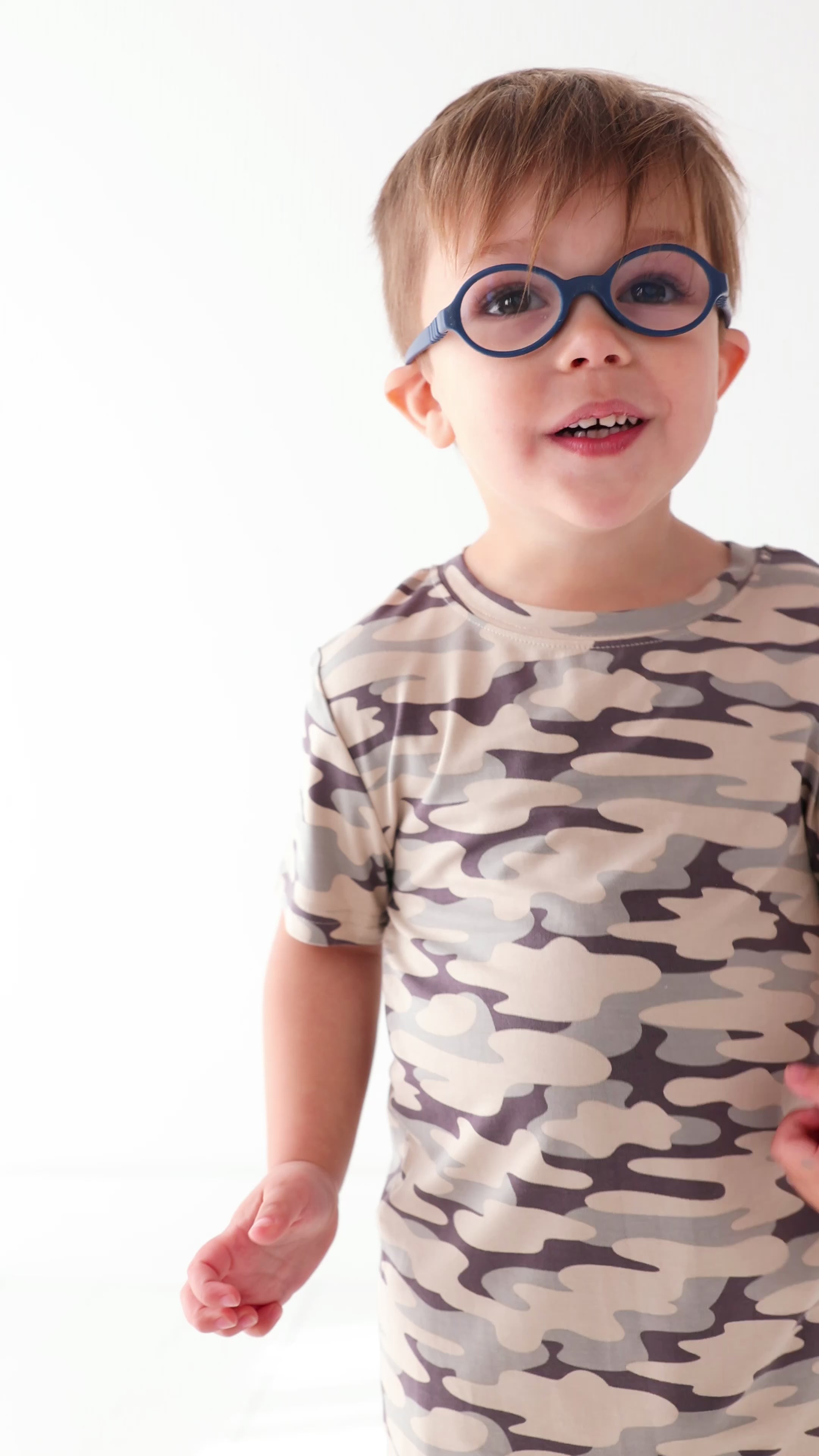 Video of a child wearing a camouflage short pajamas on a white background