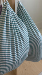 Video of blue and white striped sheets hanging on a rack