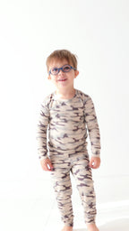Video of a child wearing a camouflage long sleeve pajama set on a white background