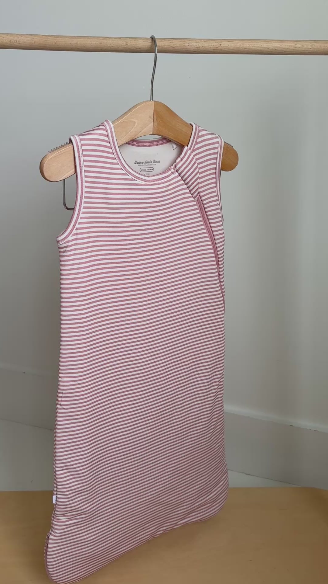 Pink striped sleeping bag hanging on a rack