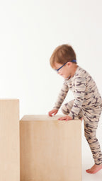 Video of a child wearing a camouflage long sleeve pajama set on a white background