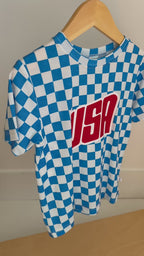 Blue and white checkered t-shirt with 'USA' print hanging on a rack