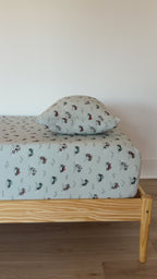 Twin-sized bed with a vehicle patterned bedding and pillow