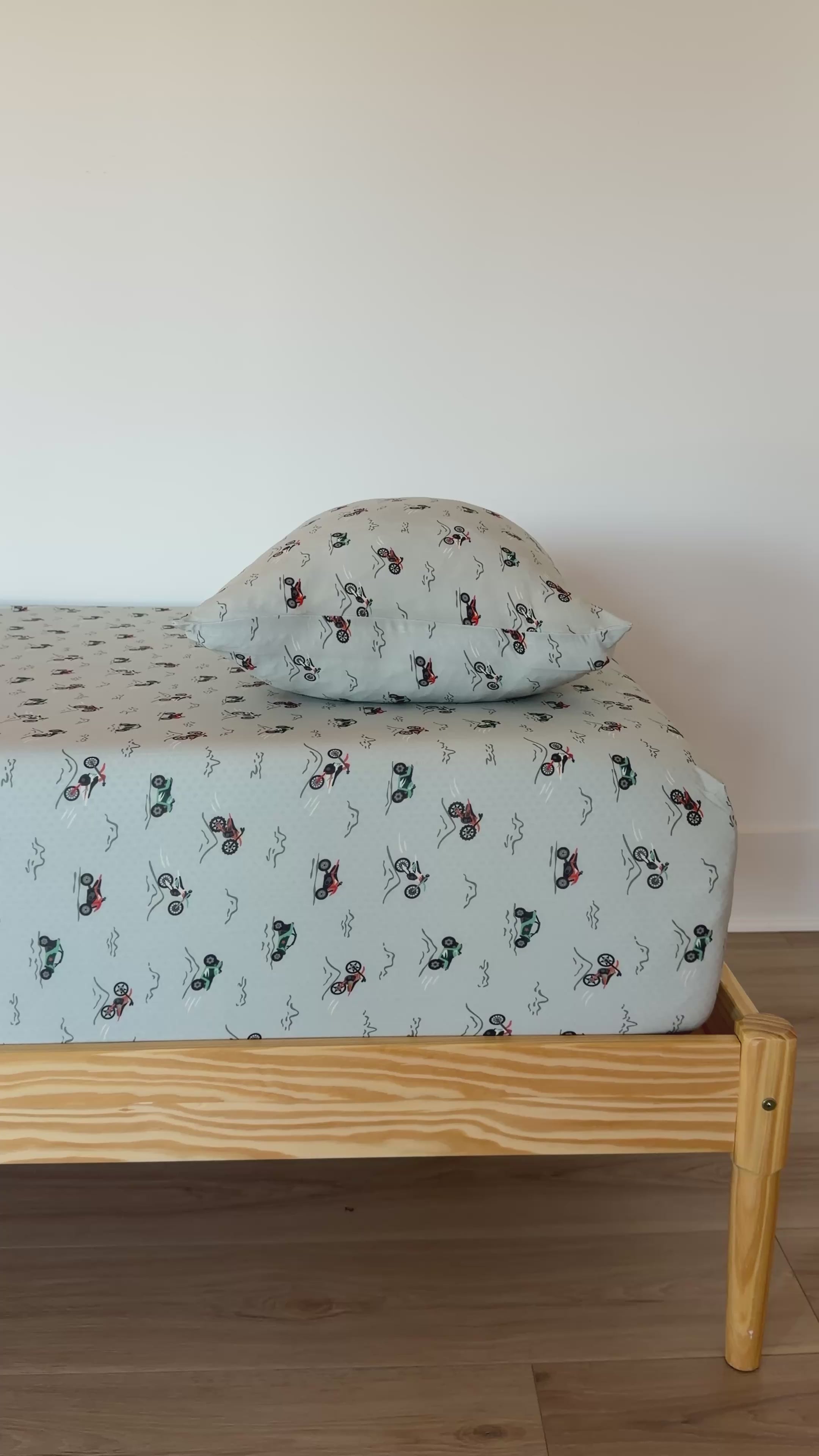 Twin-sized bed with a vehicle patterned bedding and pillow