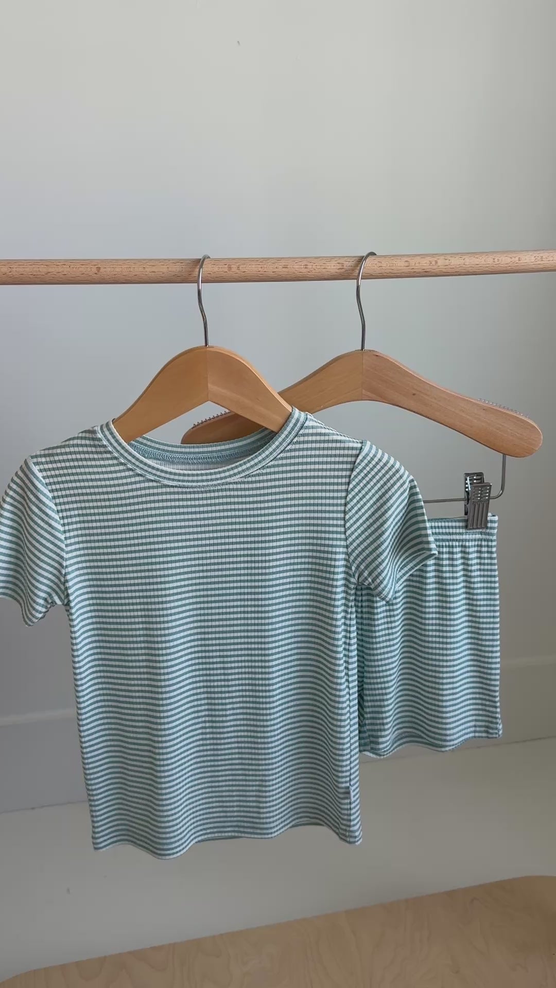 Striped t-shirt and shorts set hanging on a rack