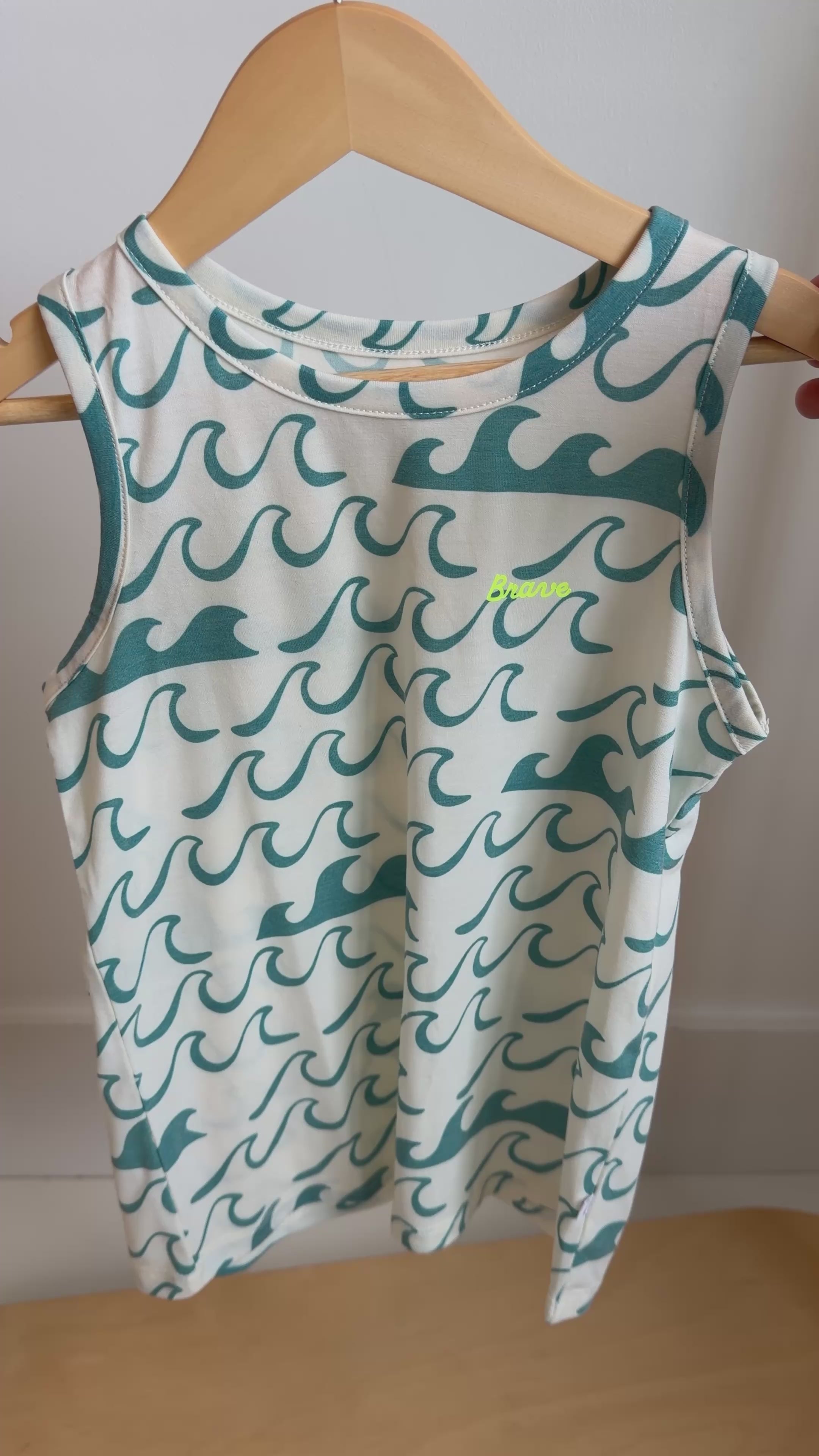 Tank top with blue wave pattern hanging on a rack
