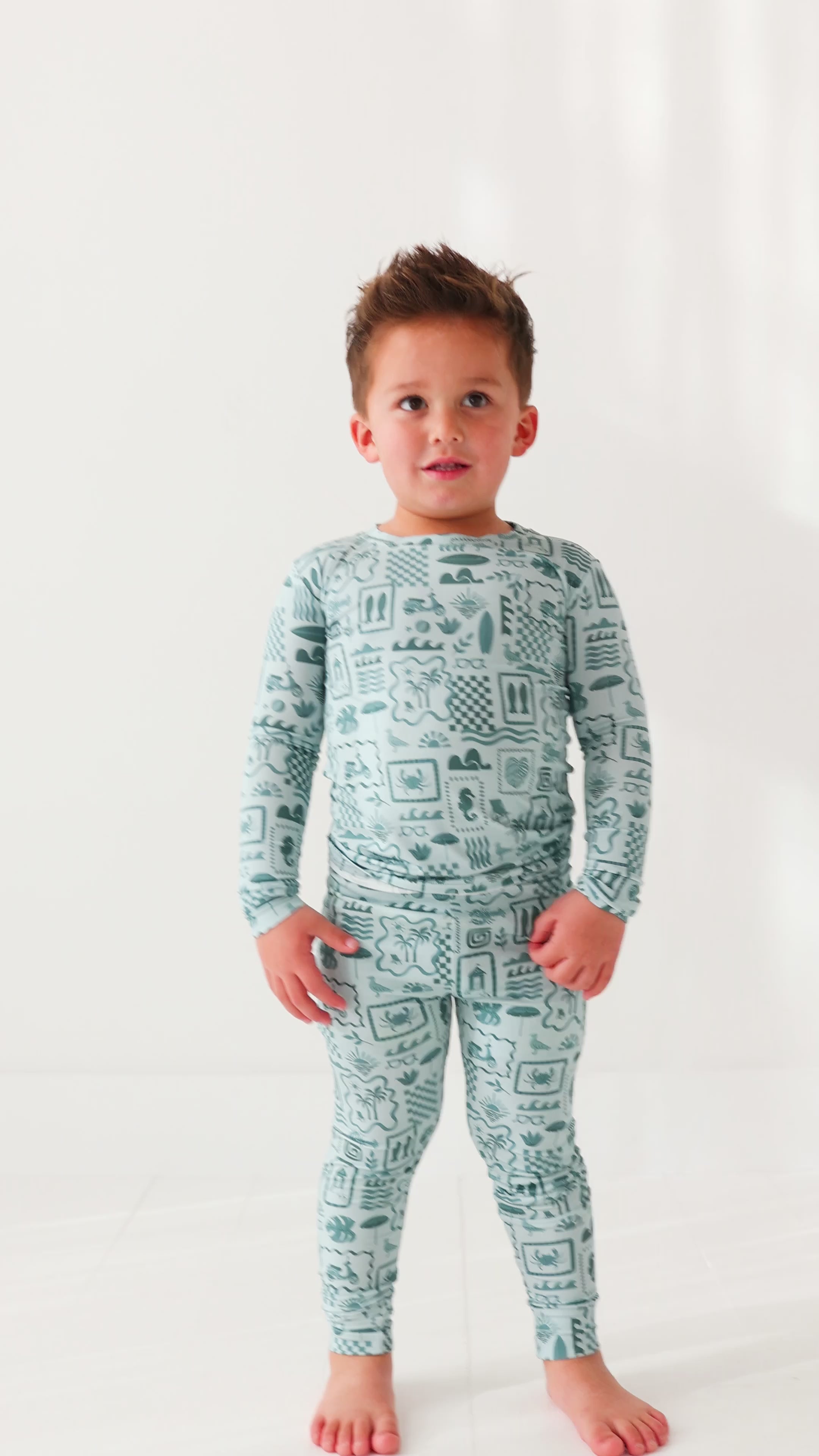 Child wearing a blue summer-patterned pajama set on a white background